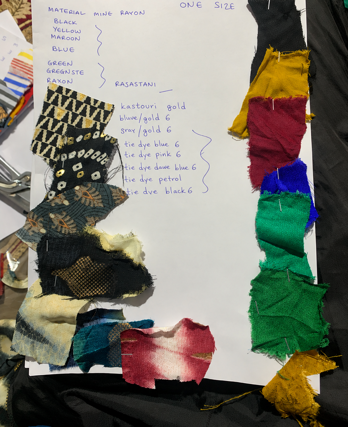 Fabric swatches pinned beside handwritten colour notes